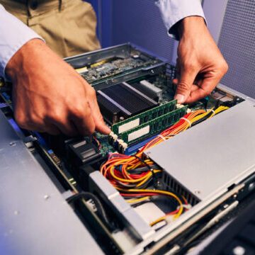 Cropped photo of experienced male IT technician removing RAM module from main logic board